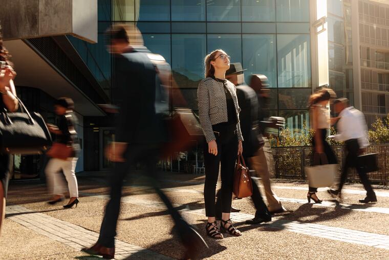 Woman stopping in busy city surrounding